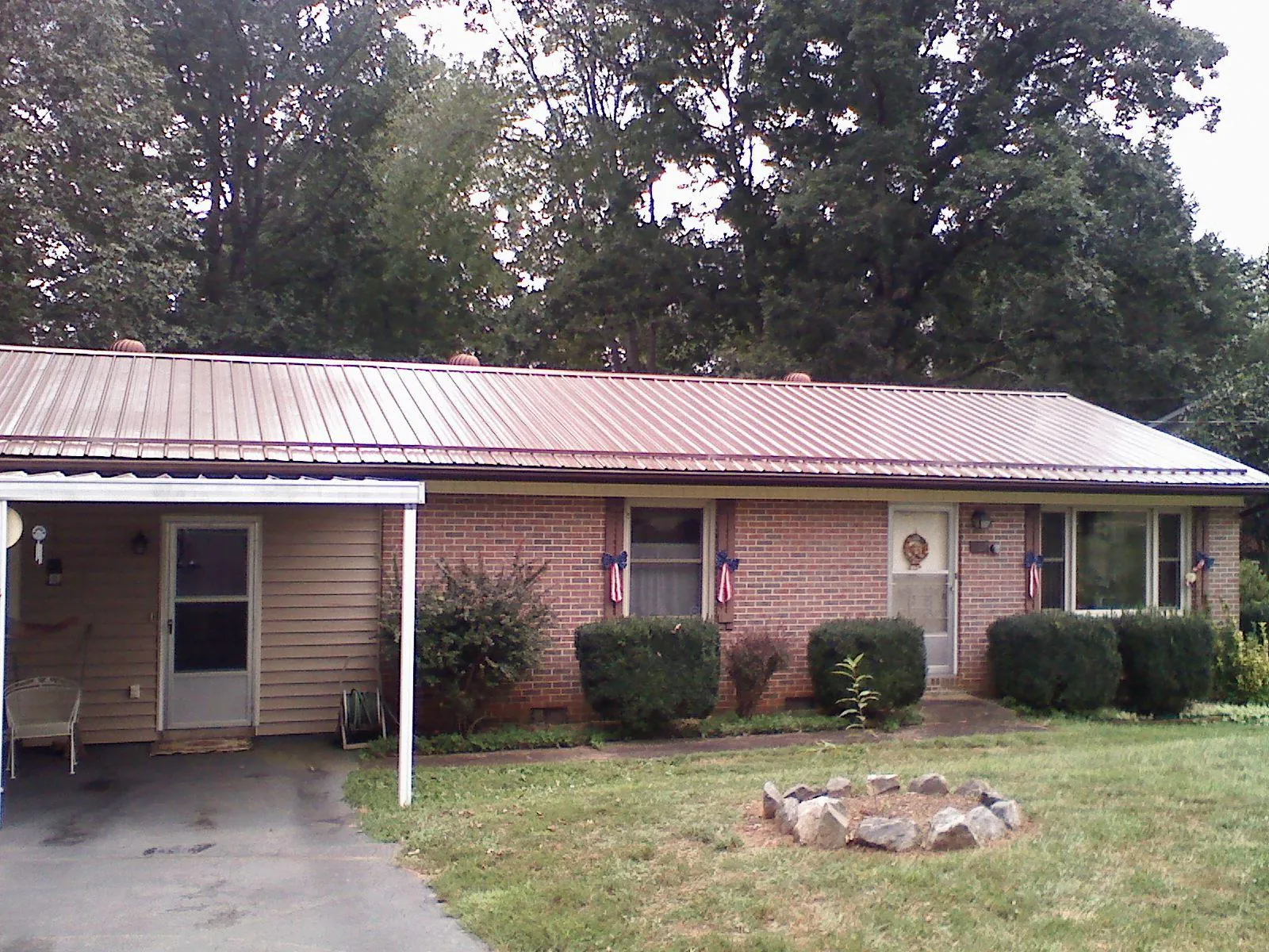 Bronze metal roof and carport on a brick ranch home — Roof Repair work by our crew in Alpha